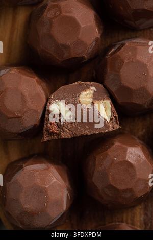 Handgemachte Schokoladentrüffel mit Nüssen auf Holzoberfläche Stockfoto