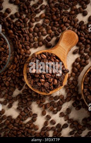 Geröstete Kaffeebohnen in einer Holzschaufel auf Stein Stockfoto