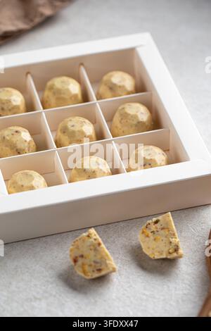 Weißschokoladen-Handwerkspralinen in einer Geschenkschachtel Stockfoto