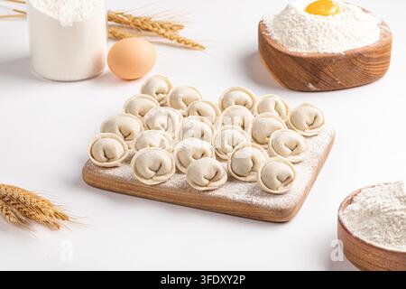 Rohe hausgemachte Pelmeni-Teigtaschen auf Schneidebrett Stockfoto