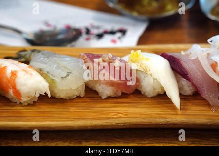 Oberansicht eines assortierten Premium-Sushi-Tellers auf einem Holzbrett Stockfoto