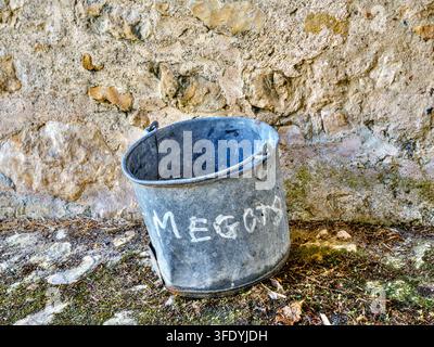 Alter Metall-Eimer mit handbemaltem Wort "Megots" für gebrauchte Zigarettenstummel - Priorat Le Louroux, Indre-et-Loire (37), Frankreich. Stockfoto