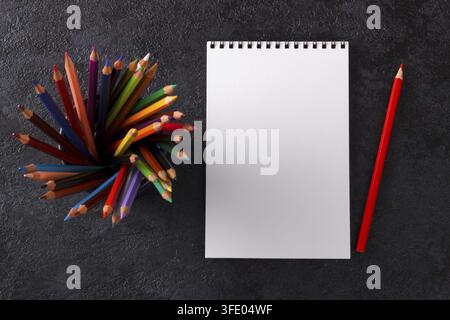 Leeres Notizbuch Skizzenbuch bunte Stifte auf dunklem modernem Bürotisch Mockup Top-Down-Ansicht Stockfoto