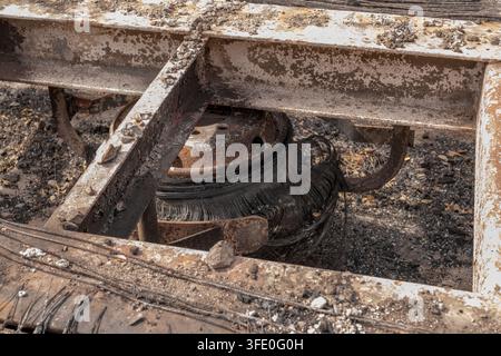 Eine Nahaufnahme zeigt verkohlte Industrieanlagen mit verrostetem Metall, Asche und Ruß. Stockfoto