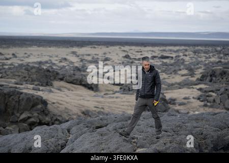 NASA-Astronautenkandidat Yuri Kubo geht über einen Lavafluss in Island während einer geologischen Feldtrainingsexpedition von Artemis, wobei er das vielfältige vulkanische Gelände des Landes nutzt, um Mondoberflächenwissenschaftsoperationen zu simulieren. Stockfoto