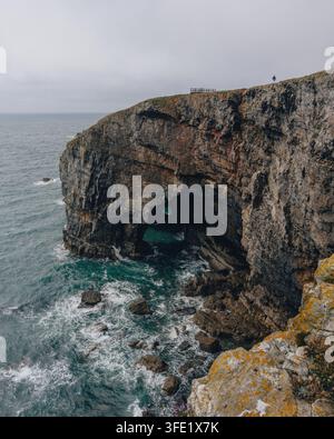 Blick auf die Green Bridge of Wales, einen natürlichen Kalksteinbogen mit schroffen Klippen und brandenden Wellen in Pembroke, Vereinigtes Königreich. Stockfoto