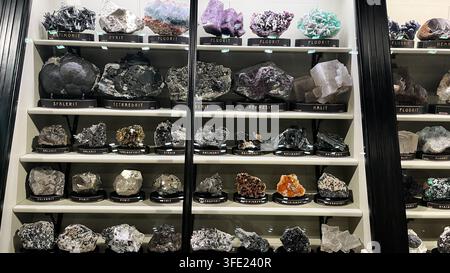 Sammlung farbenfroher Mineralien und Kristallproben, die auf Museumsgestellen beschriftet sind. PRAG, TSCHECHISCHE REPUBLIK, 15. SEPTEMBER 2025 Stockfoto