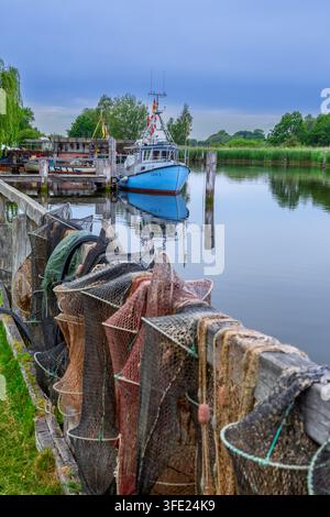 Fyke-Netze trocknen und Fischerboot im alten Hafen von Gothmund vertäut, Fischerdorf an der Trave, Schleswig-Holstein, Deutschland Stockfoto