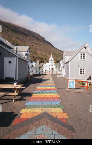 Seyðisfjarðarkirkja, die Blaue Kirche, in Seyðisfjörður Island, unter den umliegenden Berghängen, August 2026 Stockfoto