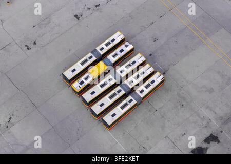 Luftbild mehrerer CNG-grüner Busse, die in einer ordentlichen Reihe auf einem großen Depot in Polen geparkt sind. Stockfoto