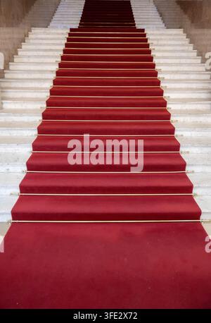 Roter Teppich auf aufsteigenden Treppen im Innenraum Stockfoto