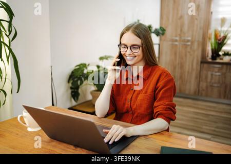 Junge Frau, die Multitasking im Homeoffice arbeitet Stockfoto