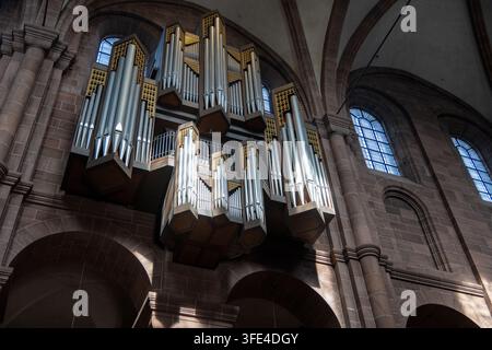 Große silberne Orgel, die über Steinbögen in der Dom St. Peter-Kathedrale in Worms, Deutschland, montiert ist. Stockfoto