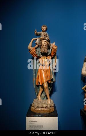 Freiburg, Deutschland – 20. Sep. 25: Mittelalterliche bemalte Skulptur des heiligen Christophorus, der das Christuskind trägt, ausgestellt im Freiburger Münster in Deutschland Stockfoto