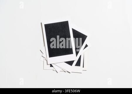 Ein minimalistischer Stapel leerer Sofortbildfotos mit weißen Rändern und schwarzen Mittelteilen, isoliert auf weißem Hintergrund. Ideal für Mockups und Nostalgie Stockfoto