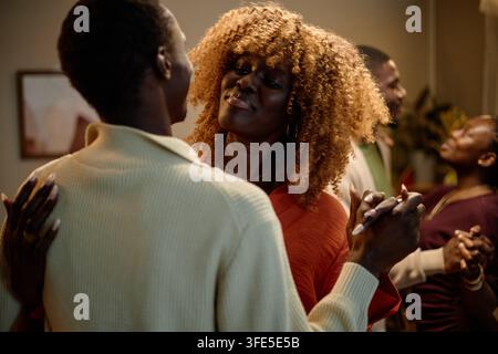 Fröhliche schwarze Freunde, die bei einem Thanksgiving-Abendessen tanzen Stockfoto
