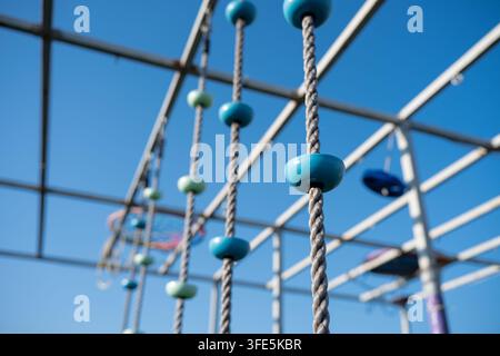 Niedriger horizontaler Schuss mit verschwommenem Hintergrund, der eine Reihe von Kletterseilen vor einem klaren blauen Himmel einfängt. Kreatives Konzept für einen aktiven Lebensstil Stockfoto