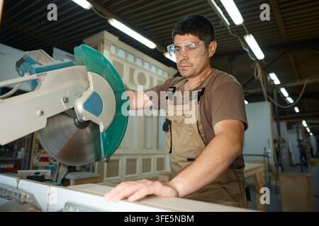 Schreiner schneidet Holz auf der Zapfensäge Stockfoto