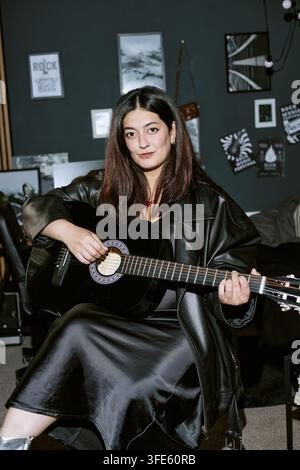 Porträt einer Frau, die im Studio Akustikgitarre spielt Stockfoto