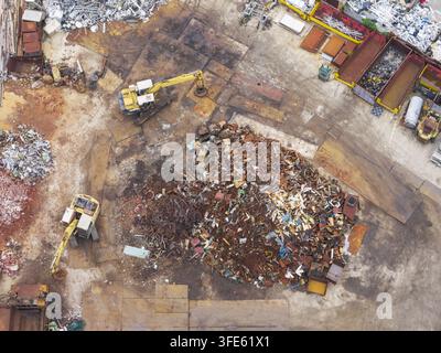 Luftaufnahme einer Ressourcenrückgewinnungsanlage mit Haufen von Schrottmetall und Baggern in Taiwan. Stockfoto