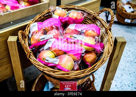 London, UK, 31. August 2026, Nahaufnahme von verpackten Pink-Lady-Äpfeln in einem Strohpräsentkorb mit einem Preisschild in einem Supermarkt von Marks und Spencer Stockfoto