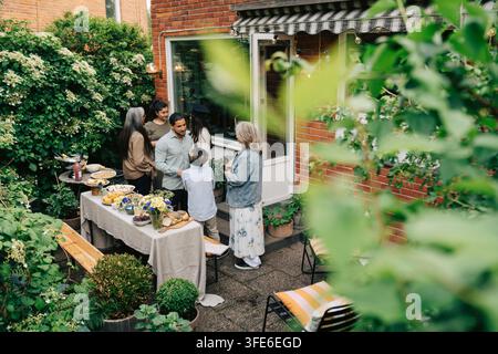 Hohe Blickwinkelansicht von Familienmitgliedern, die während einer Outdoor-Abschlussfeier stehen und plaudern Stockfoto