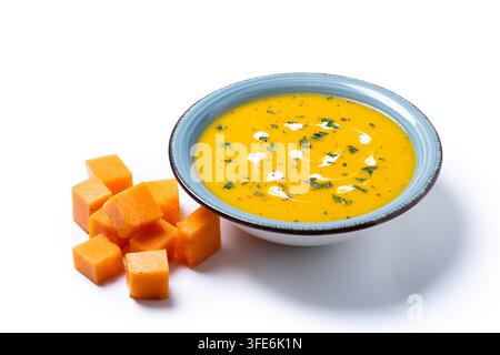 Cremige Kürbissuppe mit Kräutern und Sahne in blauer Schale isoliert auf weißem Hintergrund Stockfoto