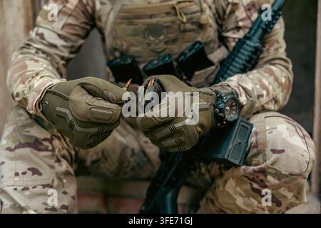 Ein Soldat lädt Patronen in ein Maschinengewehr-Magazin. Nahaufnahme Stockfoto