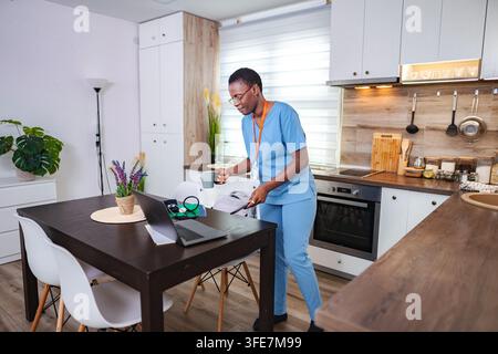 Ärztin steht in der Küche und bereitet sich auf eine Telemedizin-Beratung vor Stockfoto