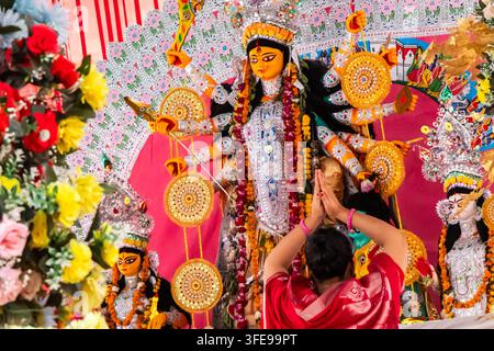junge Frauen Verehrerin, die vor dem Idol der großen Göttin Durga beim hinduistischen Dussehra-Fest betet Stockfoto