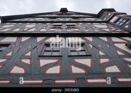 Niedrigwinkelaufnahme eines verzierten Fachwerkgebäudes in Fulda, Deutschland, das dunkle Holzbalken und Terrakotta-Details zeigt. Stockfoto