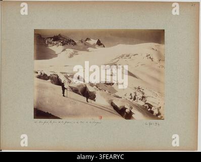 Eine schneebedeckte Berglandschaft in der Region Dauphiné in Frankreich, mit zwei Figuren, die auf einem Hang stehen, umgeben von schneebedeckten Felsen und Graten, fotografiert im Jahr 1886, als Teil eines Sets mit dem Titel "Recueil. Vues du Dauphiné et de Savoie". Stockfoto
