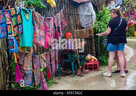 Frau der Kuna Yala verkauft Molas und andere Handarbeiten an Touristen vor einem Stammeshaus in Comarca Guna Yala, San-Blas-Inseln, Panama Stockfoto
