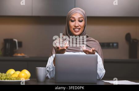 Arab Lady Machen Video Anruf Auf Laptop Online In Der Küche Stockfoto