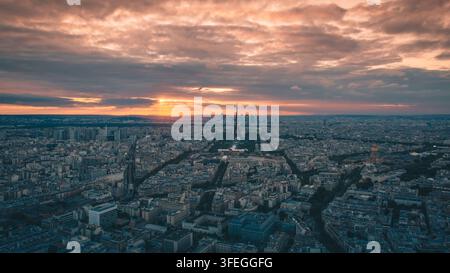 Luftbild von Paris bei Sonnenuntergang, aufgenommen vom Tour Montparnasse, mit dem Eiffelturm, der über der Stadt Skyline aufragt, und den Wolkenkratzern von La Défense Stockfoto