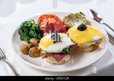 Eier Benedikt mit Lachs, Spinat, Hollandaise und schwarzem Kaviar als Topping Stockfoto