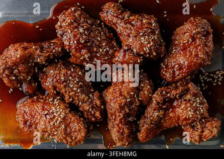 Klebrige glasierte koreanische gebratene Hühnerflügel mit Sesam Stockfoto