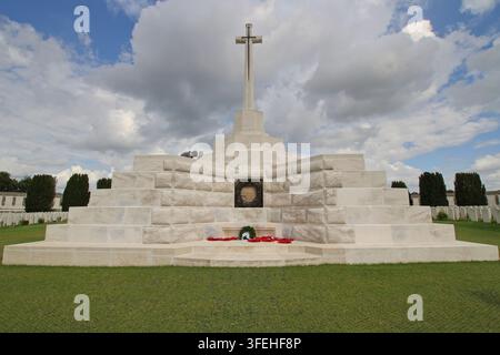 Das markante weiße Steinkreuz der Opfer, das auf einer gestuften Terrassenanlage mit Mohnblumenkränzen auf dem Tyne Cot Militärfriedhof steht. Stockfoto
