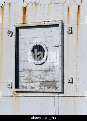 Nahaufnahme eines alten Schiffsluken und abblätternder Farbe auf einem weißen Metallrumpf mit Rostflecken Stockfoto