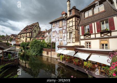 Bezaubernder Blick auf historische Fachwerkhäuser und ein Kanalrestaurant im berühmten Stadtteil Kleines Venedig von Colmar, Elsass, Frankreich. Stockfoto