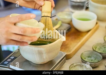 Zubereitung von Matcha-Grüntee mit Bambusrührer und Schüssel Stockfoto