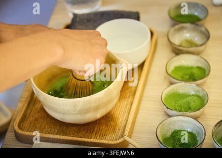 Vorbereitung von Matcha-Tee mit traditionellem Bambusquirl Stockfoto