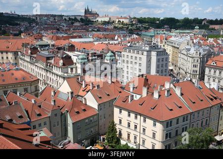 Prag, Tschechische Republik; 18. Mai 2026: Panoramablick auf rotgedeckte Dächer mit der Prager Burg in der Ferne sichtbar Stockfoto