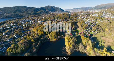 Luftaufnahme des Myravatnet-Sees in Bergen, Norwegen, mit lebendigem Herbstlaub, das die malerische Wohngegend umgibt Stockfoto