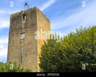 Steinerner befestigter Uhrturm mit einer Glocke, umgeben von Bäumen, Gers, Tilliac, Frankreich Stockfoto