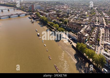 Eine Luftaufnahme von Booten, die an der Themse bei Putney Embankment und Bridge in Wandsworth, London, festgemacht sind, und die die städtische Uferpromenade zeigen. Stockfoto