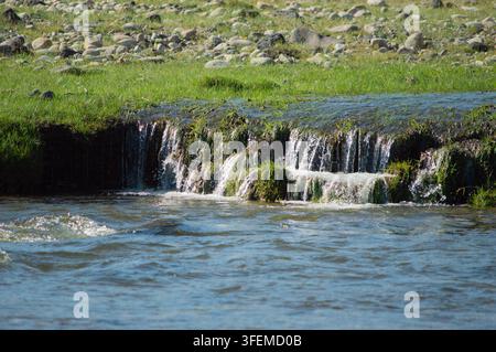Orchon-Tal, Mongolei – 5. August 2026: Ein klarer Bergbach stürzt über einen Felsvorsprung. Stockfoto