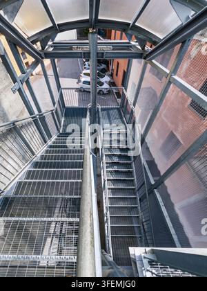 Industrielle Außentreppen für Notfälle aus verzinktem Stahl. Hochwinkelperspektive, die die Treppenstruktur hinab schaut, mit Anti- Stockfoto