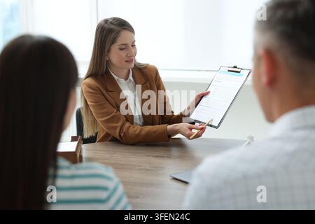 Notar arbeitet mit Klienten am Tisch im Büro Stockfoto