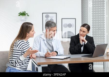 Notar arbeitet mit Klienten am Tisch im Büro Stockfoto